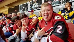 A group of young men sitting in the stands at a baseball game.