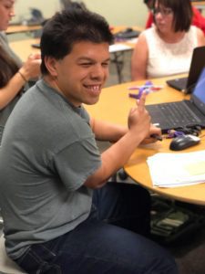 A man sitting at a table with a laptop.