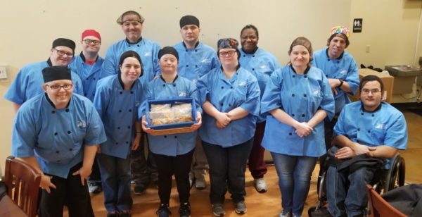 A group of people in blue uniforms holding food.