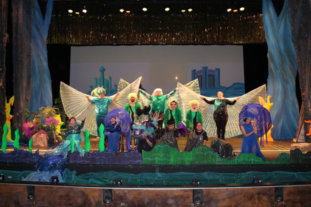 A group of people in costumes on stage.